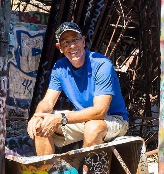 Guri Stark Person sitting with metal railing behind him.